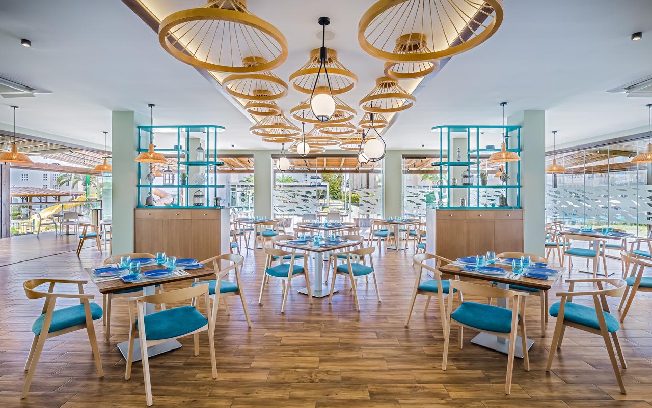 Restaurant van Occidental Torremolinos Playa met turquoise stoelen